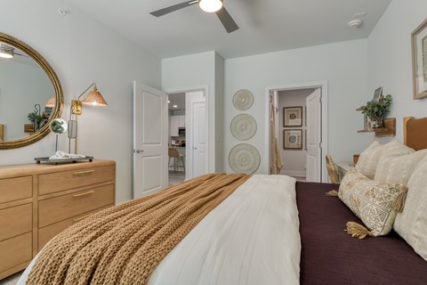 A bedroom with a large bed and a mirror on the wall.