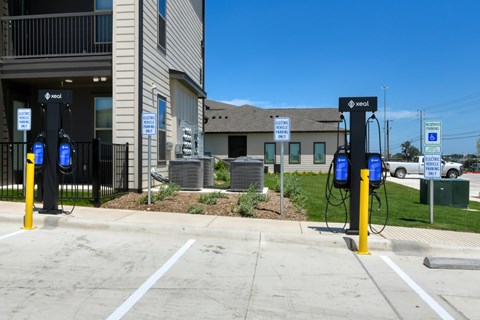 Two electric vehicle charging stations are located outside a building.