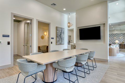 A conference room with a long table and chairs.