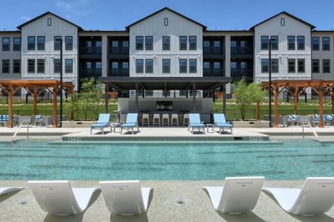 A large building with a pool in front of it.
