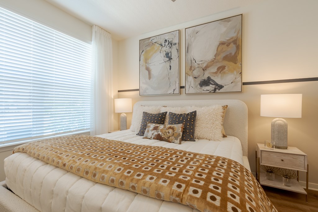 A bed with a white comforter and a brown patterned duvet cover.