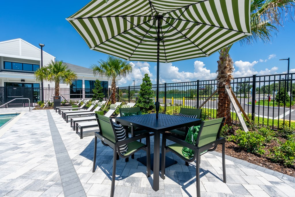 A patio with a table and chairs under an umbrella.