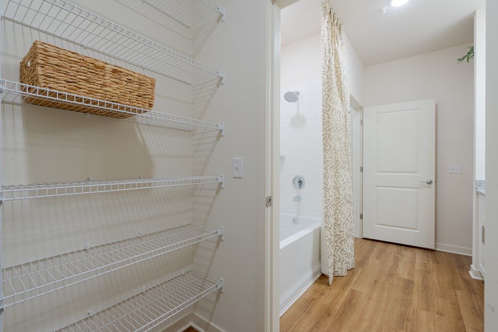 A white pantry with a basket on the shelf.