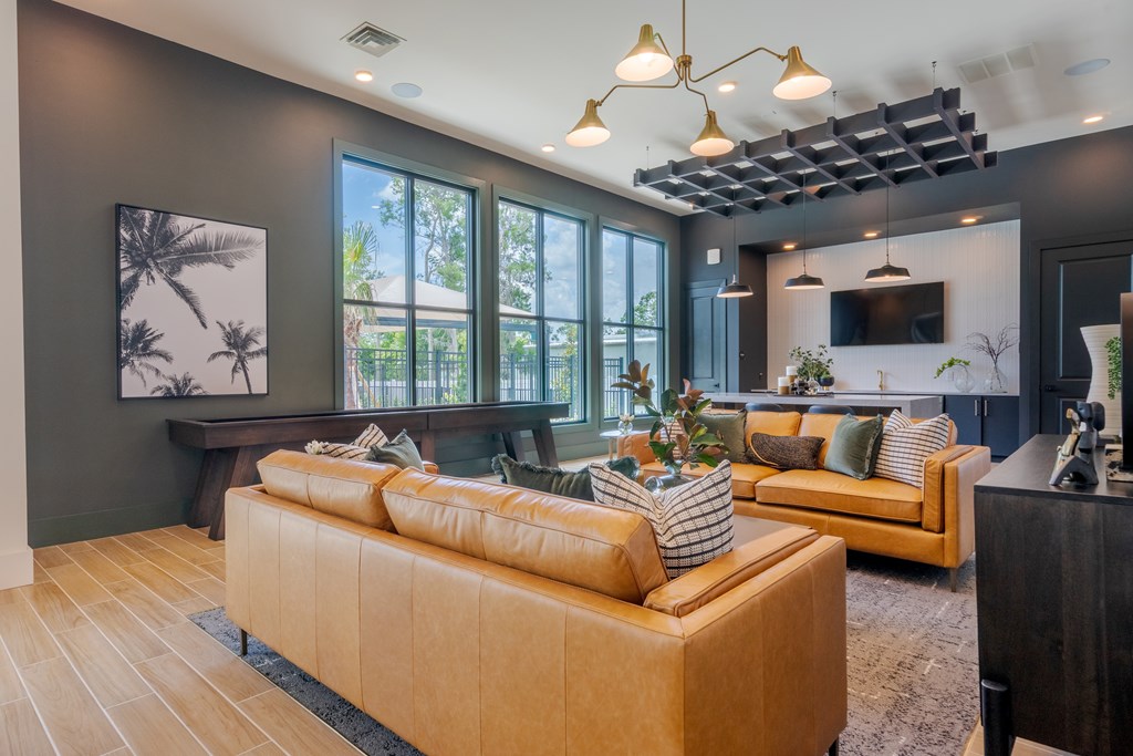 A living room with a tan sofa and a wooden floor.