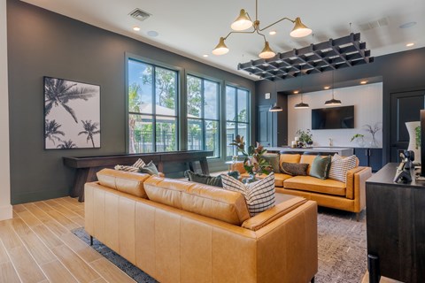 A living room with a tan sofa and a wooden floor.