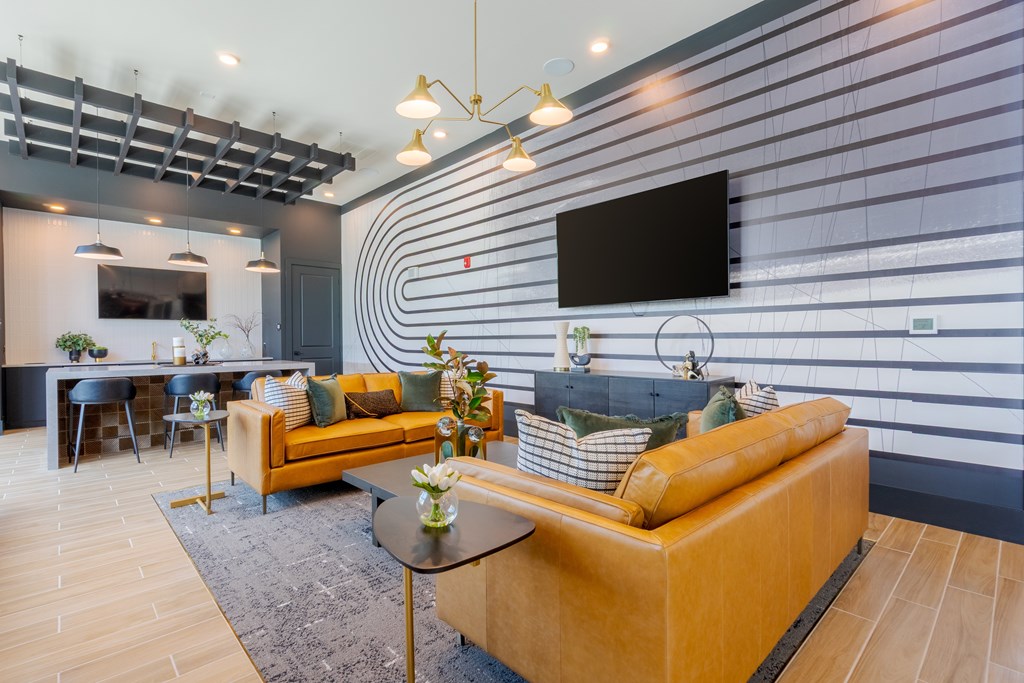 A modern living room with a yellow couch and a flat screen TV mounted on the wall.