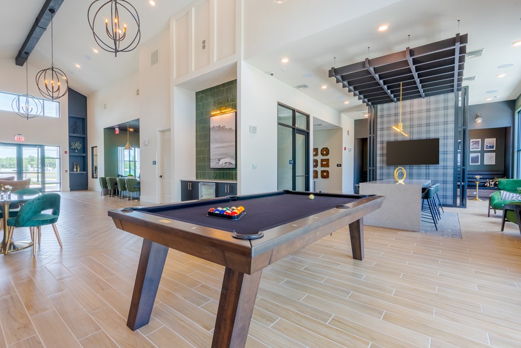 A pool table in a room with a wooden floor.