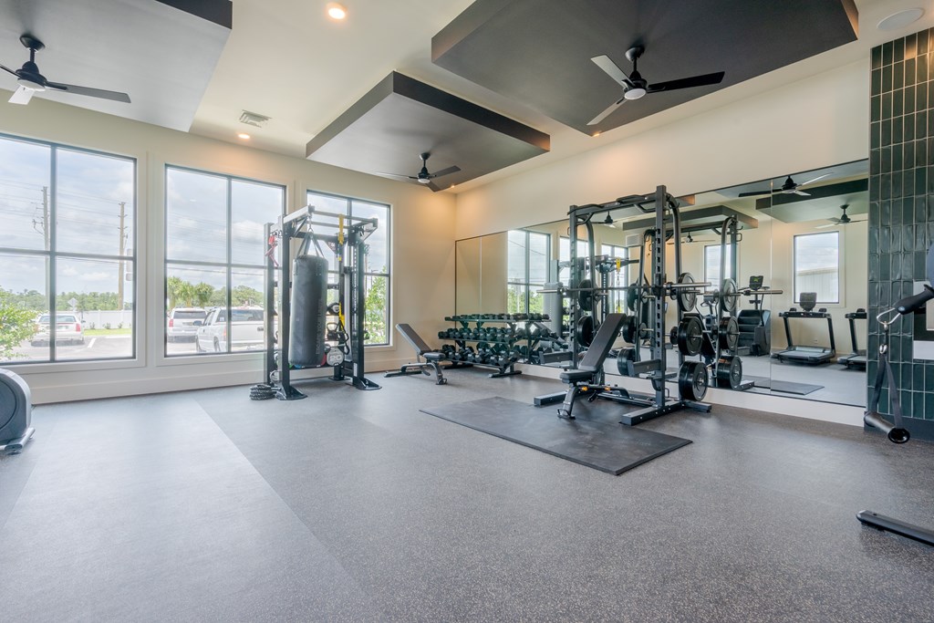 A spacious gym with a variety of equipment and a large window.
