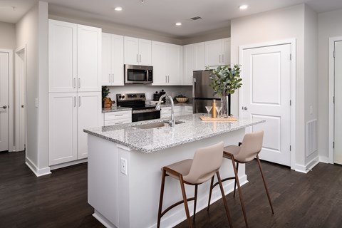 A kitchen with white cabinets and a granite countertop.