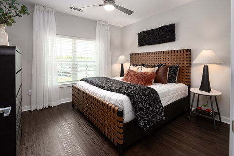 A bedroom with a large bed and a ceiling fan.