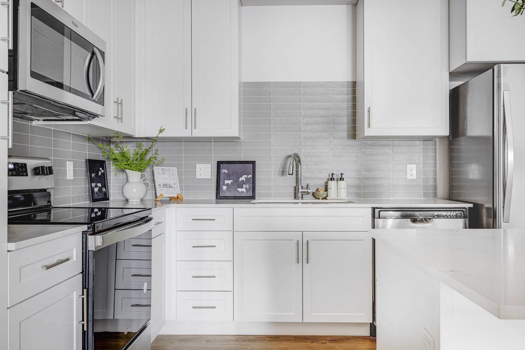 a white kitchen with white cabinets and a counter top