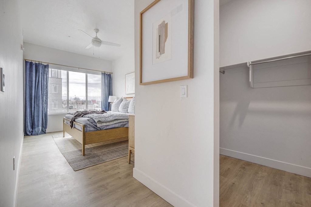 a bedroom with a bed and a large window and a closet