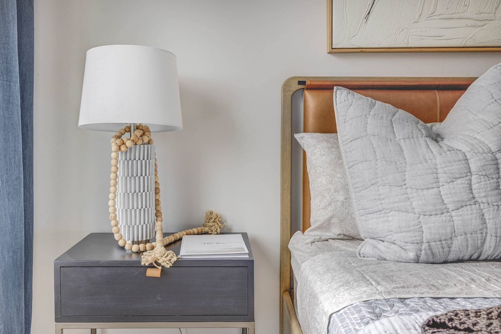 a bedroom with a bed and a nightstand with a lamp