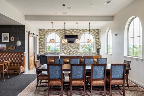 A dining room with a large table and chairs.