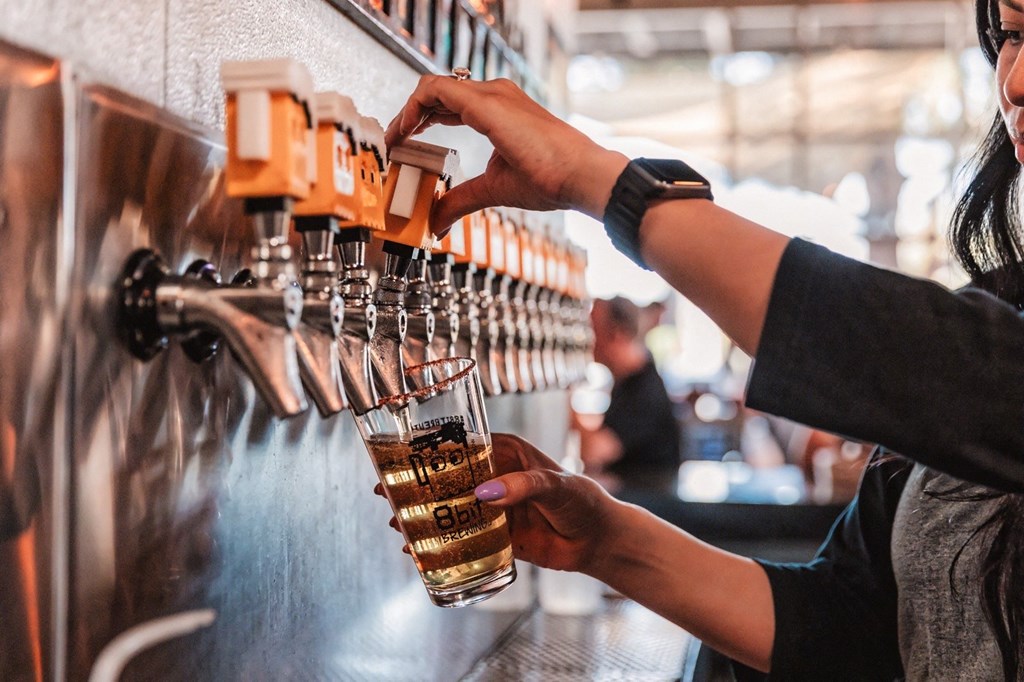 a bartender pouring a glass of beer at a bar