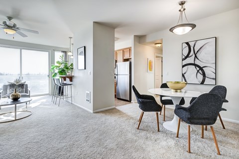 a living and dining area with a white table and black and white chairs