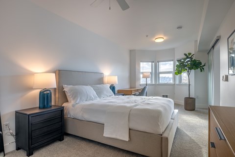 A bedroom with a large bed and a ceiling fan.