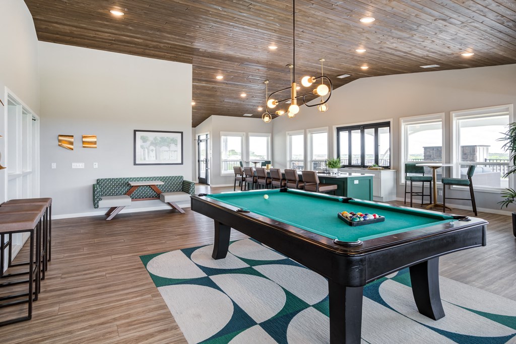an open living room with a pool table in the center of it
