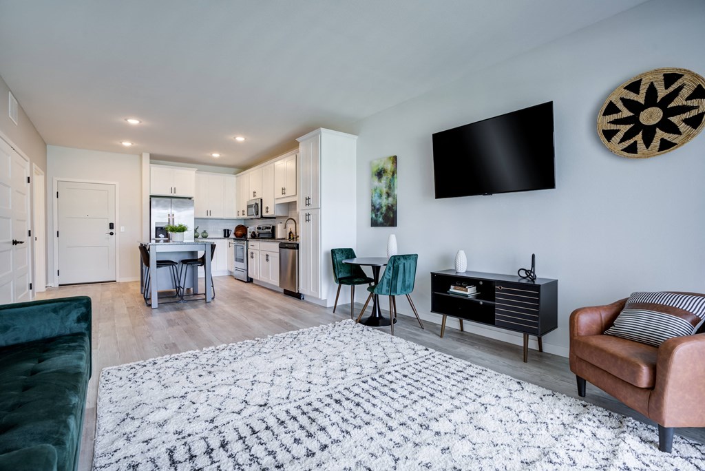 a living room with a couch and a tv and a kitchen