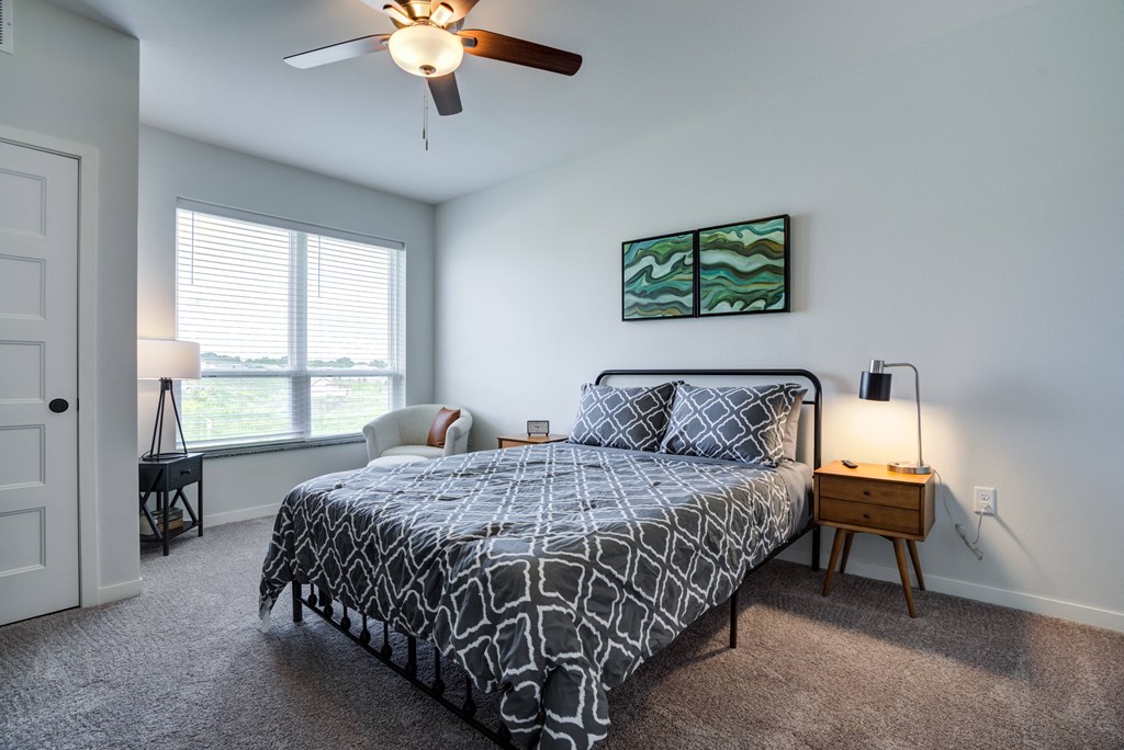 a bedroom with a bed and a ceiling fan and a window
