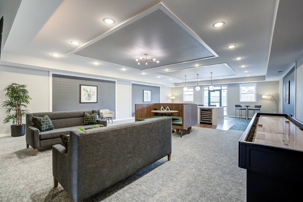 a living room with couches and a table in a room with a piano