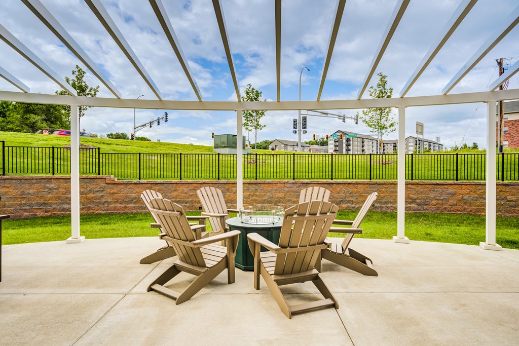 a patio with chairs and a table under a glass roof