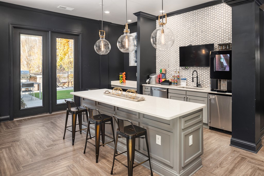 A kitchen with a white countertop and a black and white tiled backsplash.