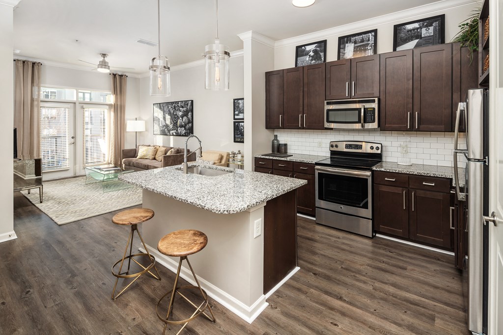A kitchen with a white countertop and wooden floors.