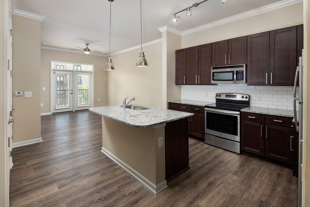 A kitchen with a white counter top and wooden cabinets.