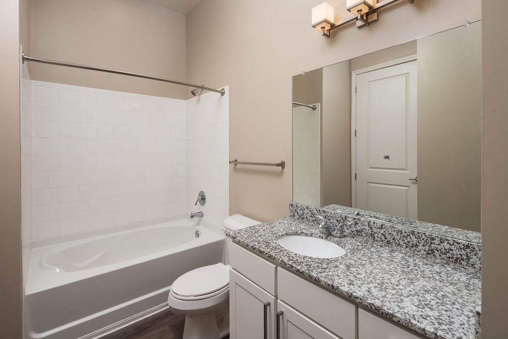 A bathroom with a tub, toilet, and sink.
