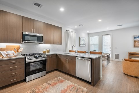A modern kitchen with wooden cabinets and stainless steel appliances.