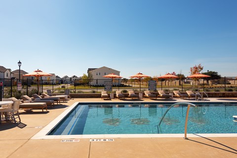 A pool with a slide and sun loungers.