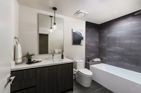 a bathroom with a toilet sink and tub and a mirror