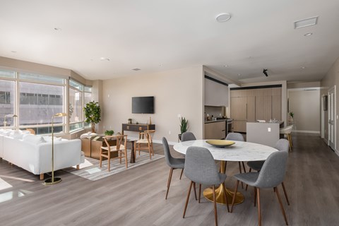 a living room and dining room with a table and chairs