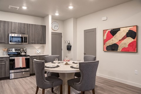 a kitchen and dining room with a table and chairs and a clock on the wall