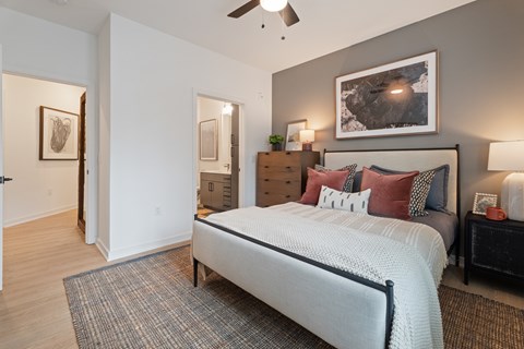 A bedroom with a large bed and a ceiling fan.