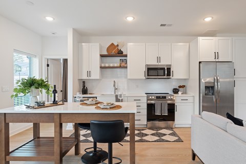 A modern kitchen with white cabinets and stainless steel appliances.