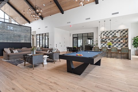 A pool table is in the middle of a room with a couch and a chair.