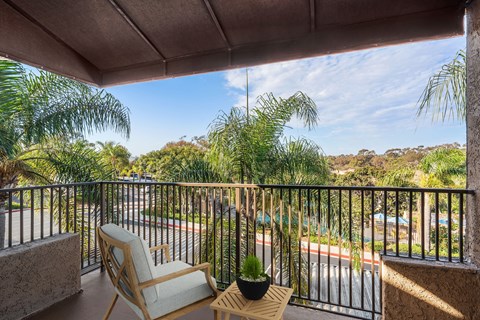 A balcony with a chair and a potted plant.