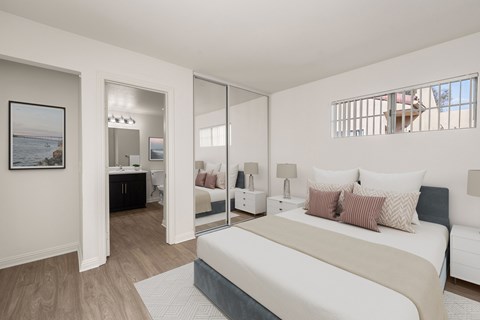 A bedroom with a large bed and a painting on the wall.