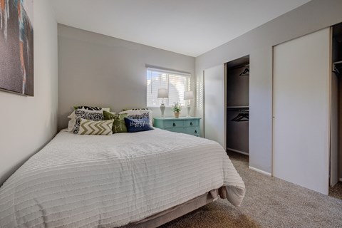 A bedroom with a large bed and a painting on the wall.