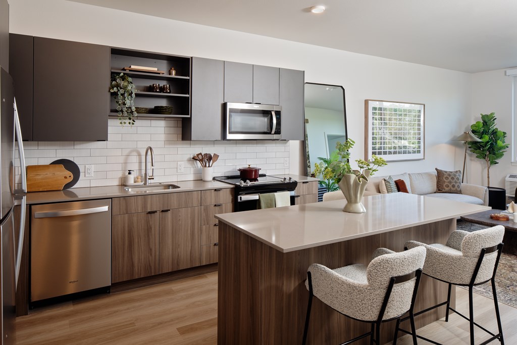 A modern kitchen with a large island and bar stools.