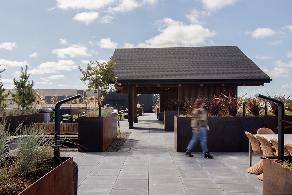 A person walks through a courtyard with a building in the background.