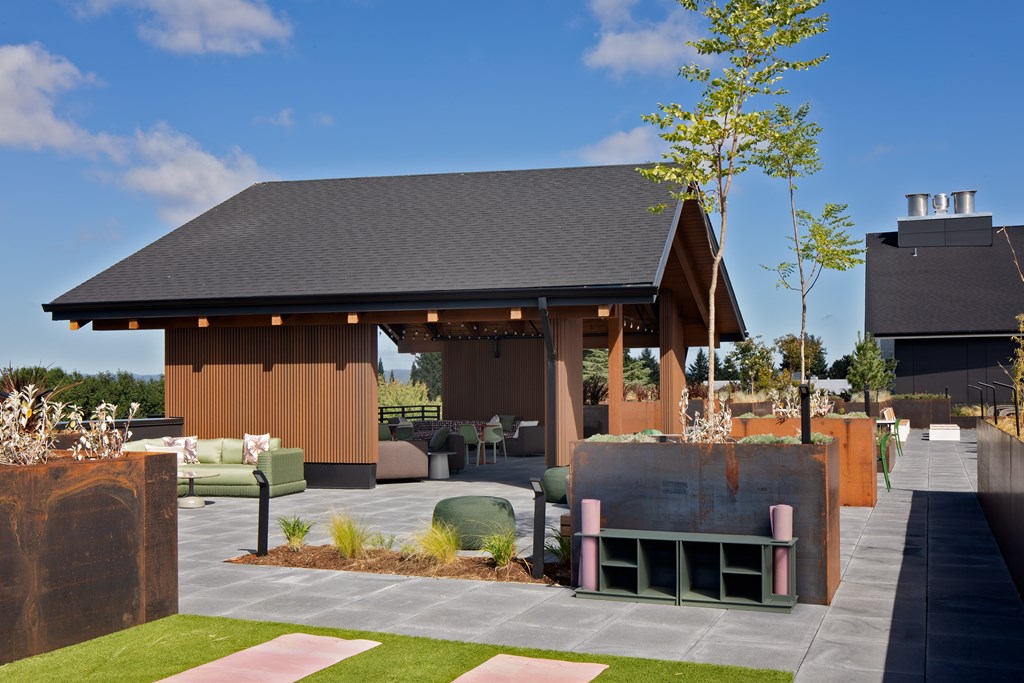 A modern house with a brown exterior and a black roof.