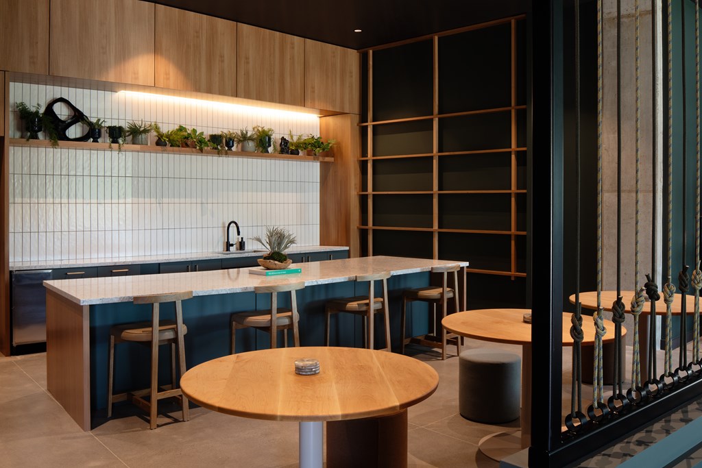 A modern kitchen with a bar area and a dining table.