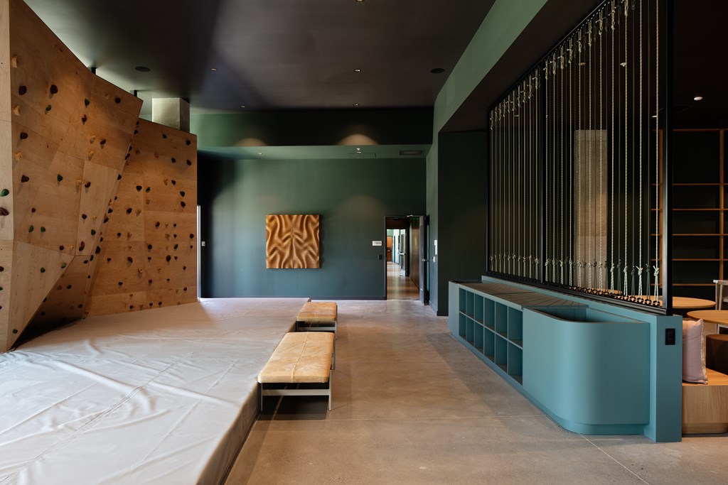 A room with a climbing wall and a bench.