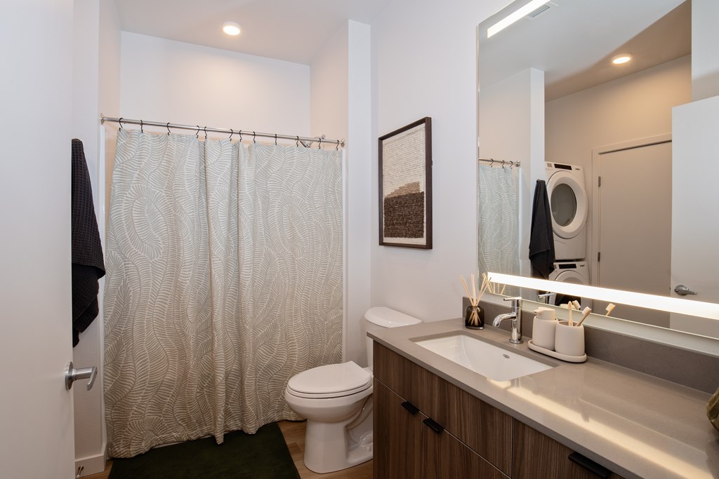 A bathroom with a toilet, sink, and shower curtain.