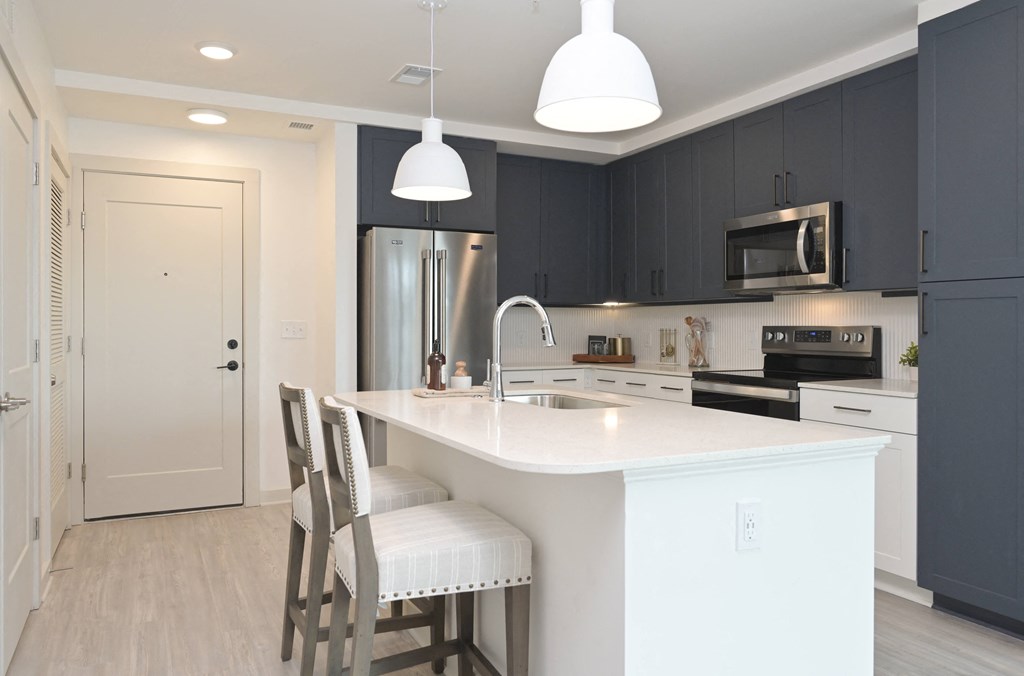 a kitchen with a white counter top and black cabinets
