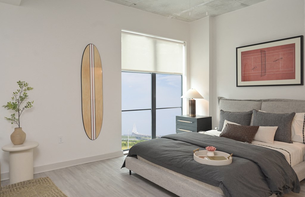 a bedroom with a large window and a bed with pillows