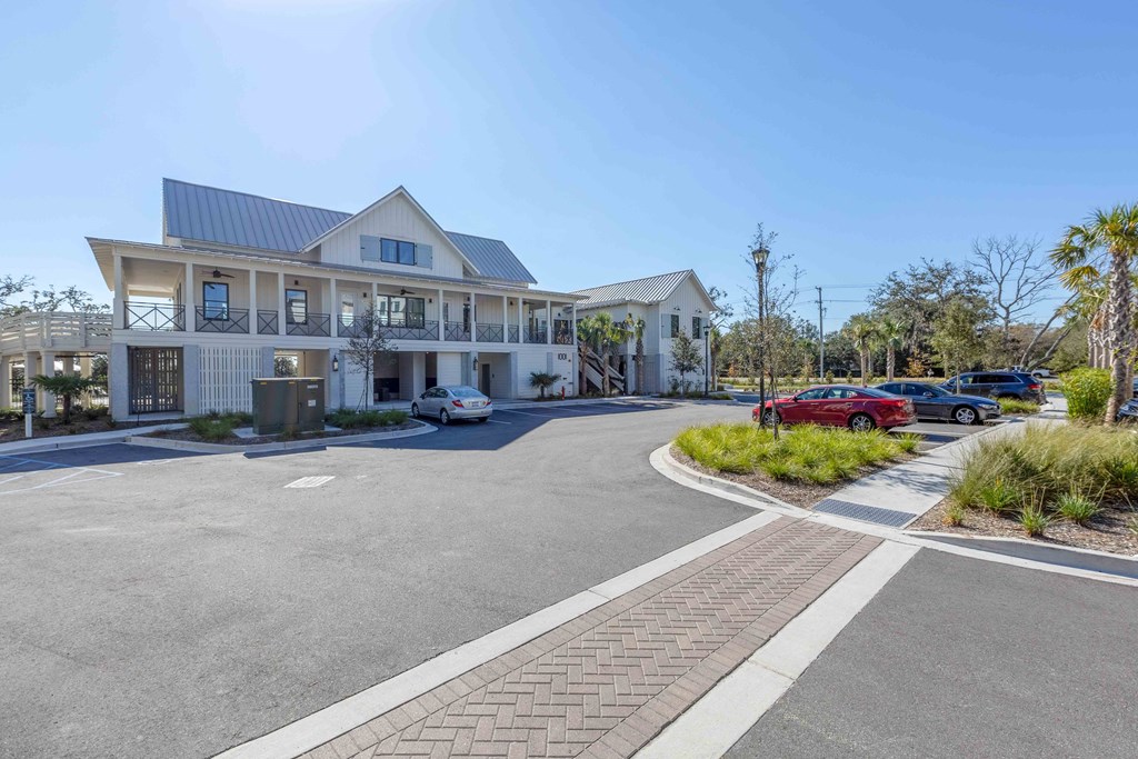 a large white building with a blue roof and a parking lot in front of it